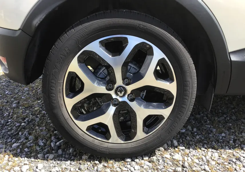 Gros plan sur la roue avant droite beige/marron du Renault Captur 2018 avec jante alliage noir et argentée signée Goodyear.