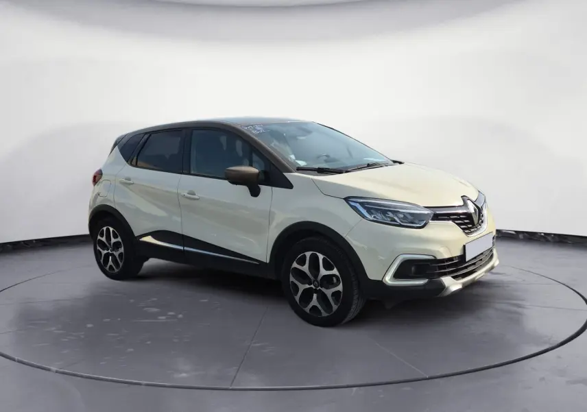 Renault Captur beige/marron vue 3/4 avant droit, avec jantes alliage et détails noirs contrastants.
