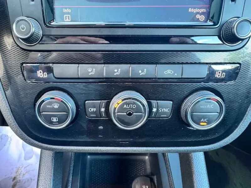 Vue rapprochée du tableau de bord de la Volkswagen Scirocco 2017, montrant les commandes de climatisation automatique bi-zone.