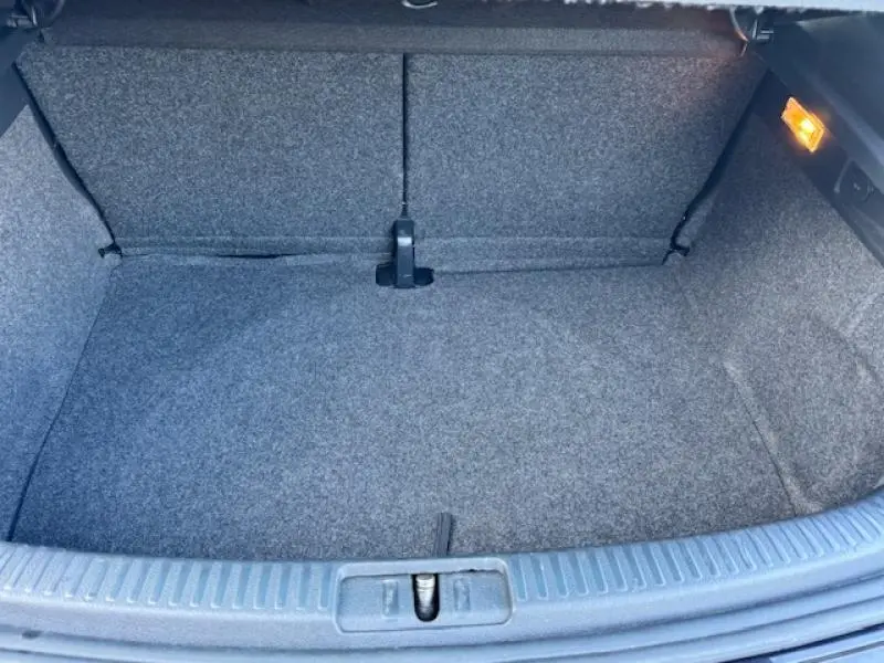 Coffre ouvert de Volkswagen Scirocco 1.4 TSI 2017, vue intérieure avec revêtement gris et éclairage latéral allumé.