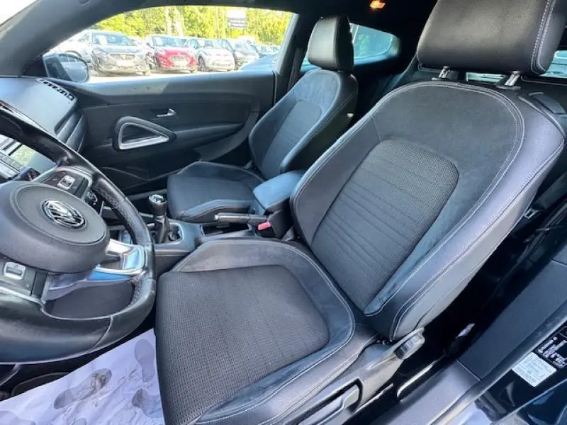 Vue intérieure côté gauche du Volkswagen Scirocco noir intense, sièges sport tissu/Alcantara et volant cuir multifonction.