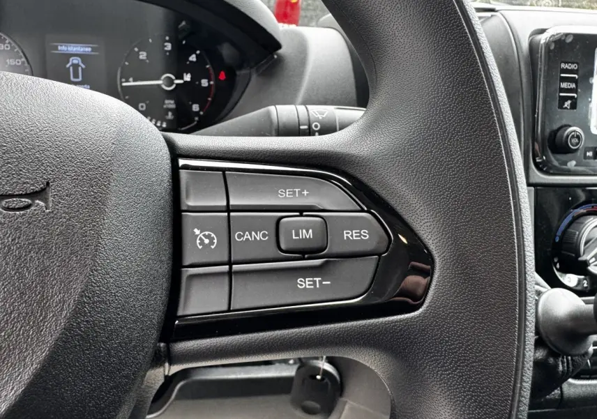 Gros plan sur le volant noir du Peugeot Boxer Fourgon 2026, montrant les commandes du régulateur de vitesse.