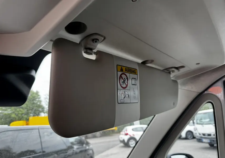 Pare-soleil gris clair côté conducteur du Peugeot Boxer Fourgon blanc, vue intérieure avec autocollant airbag visible.