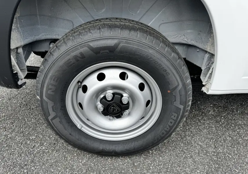 Gros plan sur la roue avant droite du Peugeot Boxer Fourgon blanc, jante acier avec logo Peugeot central.