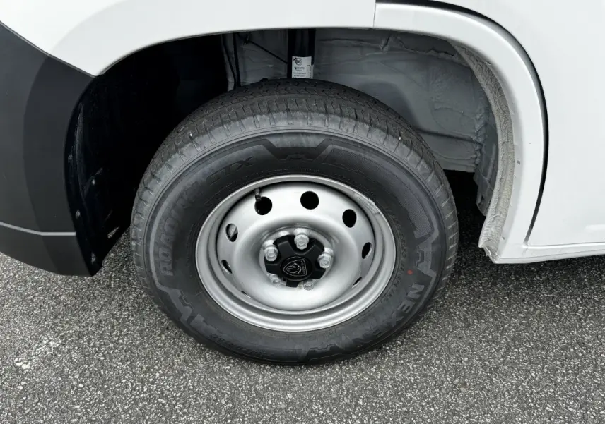 Gros plan sur la roue avant droite en jante acier du Peugeot Boxer Fourgon blanc, montrant le pneu et l'arche de roue.