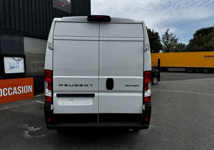 Vue arrière d'un Peugeot Boxer Fourgon blanc, portes battantes fermées, sur parking extérieur.