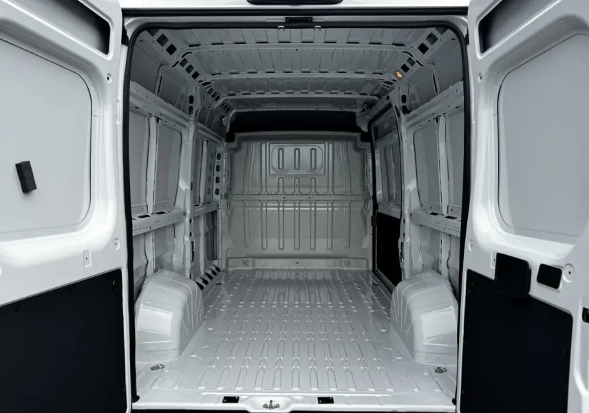 Vue intérieure arrière du fourgon blanc Peugeot Boxer L2H1 2026, montrant l'espace de chargement vide et la cloison pleine.
