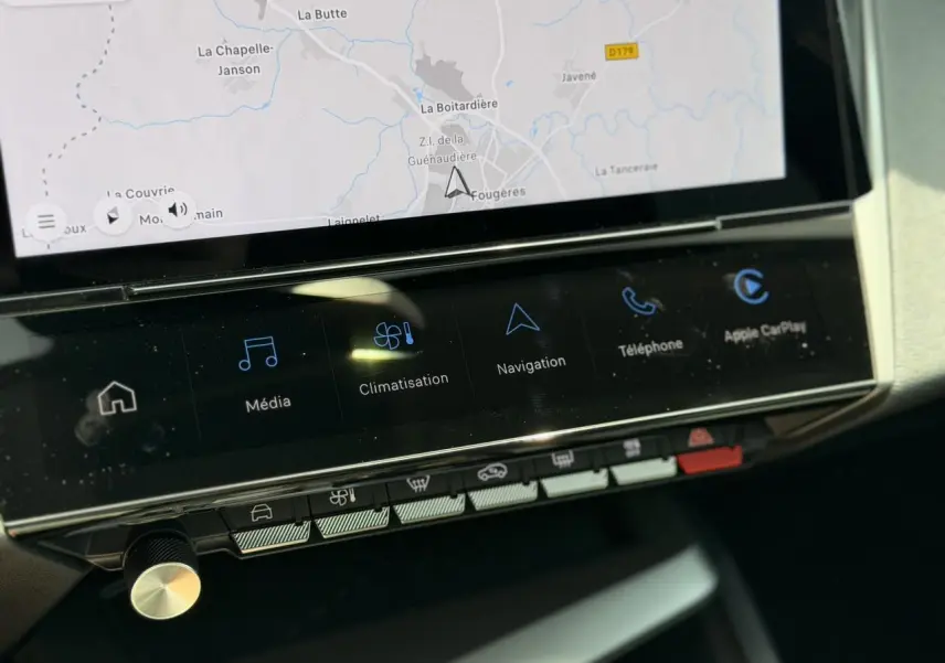 Gros plan sur l’écran tactile central 10'' de la Peugeot 308 Hybrid 2025 avec navigation et commandes climatisation.