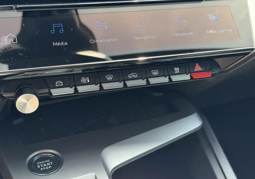 Gros plan sur la console centrale de la Peugeot 308 Hybrid 2025, montrant l'écran tactile et les commandes tactiles.