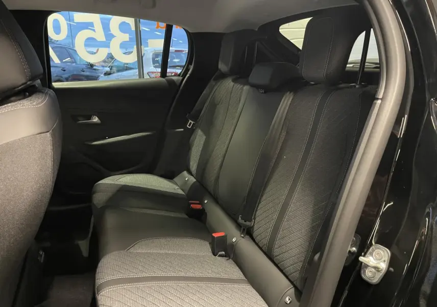 Vue intérieure côté droit sur la banquette arrière tissu noir et gris d’une Peugeot 208 noire métallisée 2025.