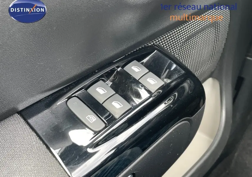 Gros plan sur les commandes des vitres électriques côté conducteur d'une Citroën C3 gris Artense métal de 2021.