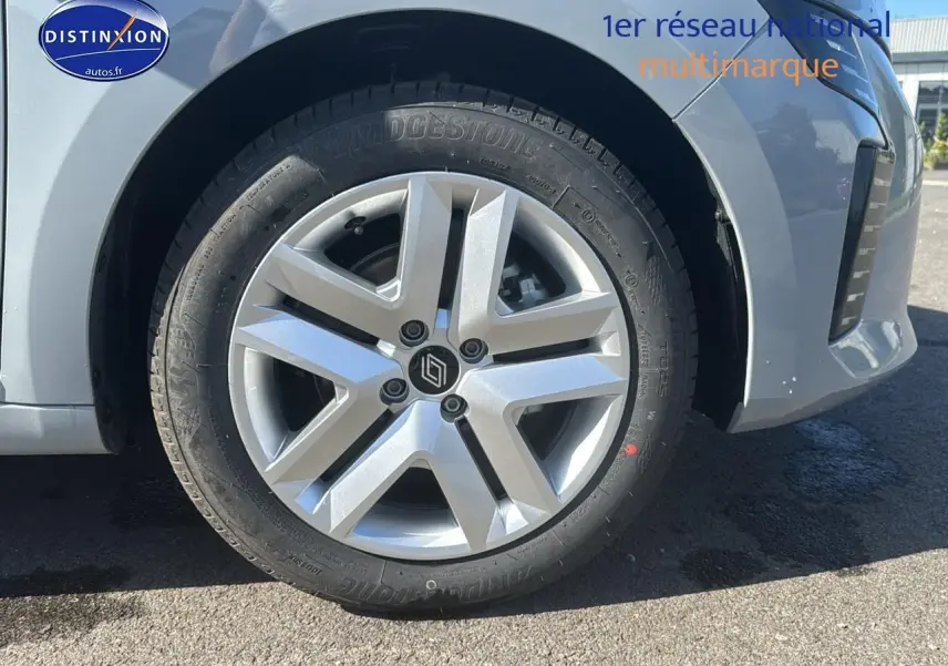 Gros plan sur la roue avant gauche de la Renault Clio V gris rafale, avec jante acier 16 pouces et logo Renault central.