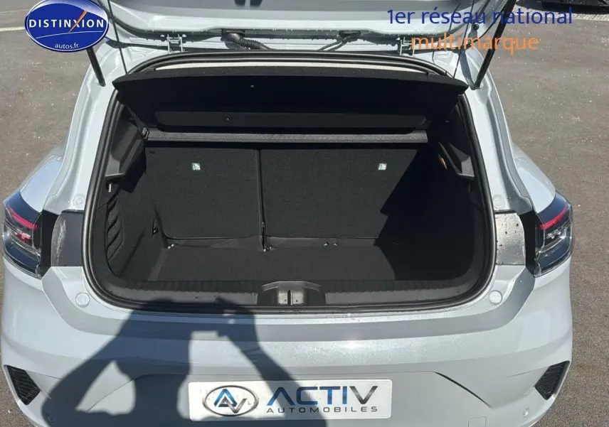 Coffre ouvert d'une Renault Clio V gris rafale vue arrière, soulignant l'espace de chargement vide.