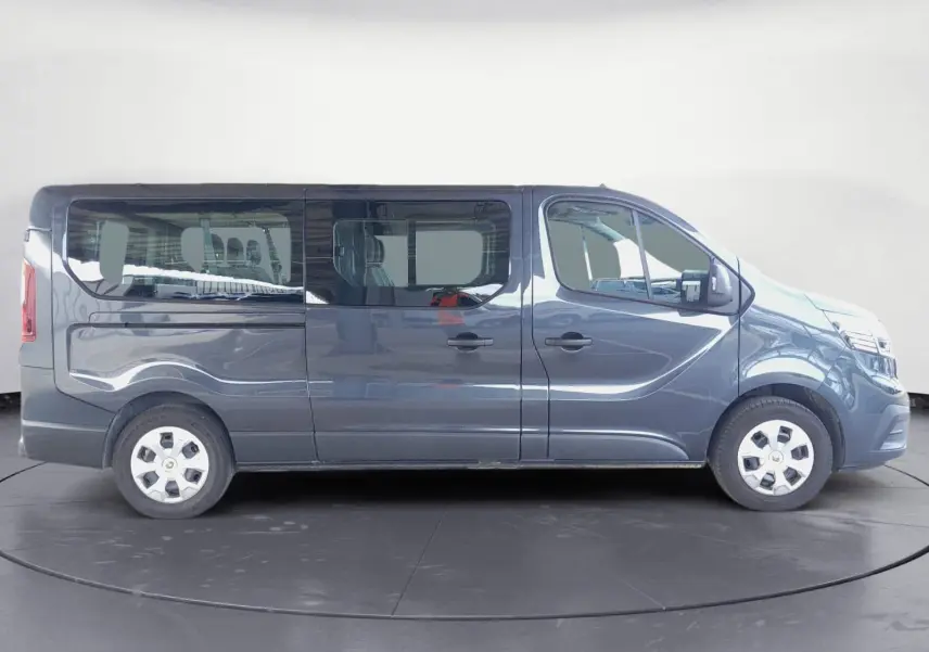 Profil côté droit d'un Renault Trafic Combi gris foncé métallisé, version 9 places, avec vitres latérales teintées.