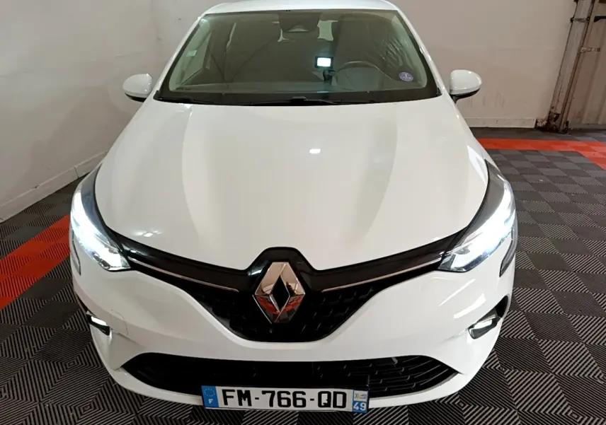 Vue frontale d'une Renault Clio Business TCe 100 blanche avec phares LED allumés et calandre noire brillante.