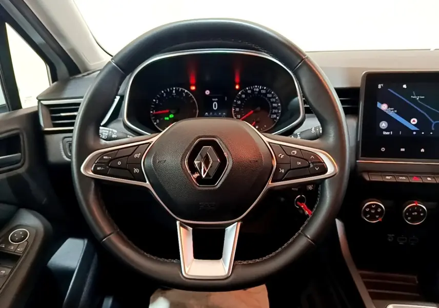 Vue rapprochée du volant en cuir noir d'une Renault Clio Business TCe 100 avec tableau de bord et écran tactile.