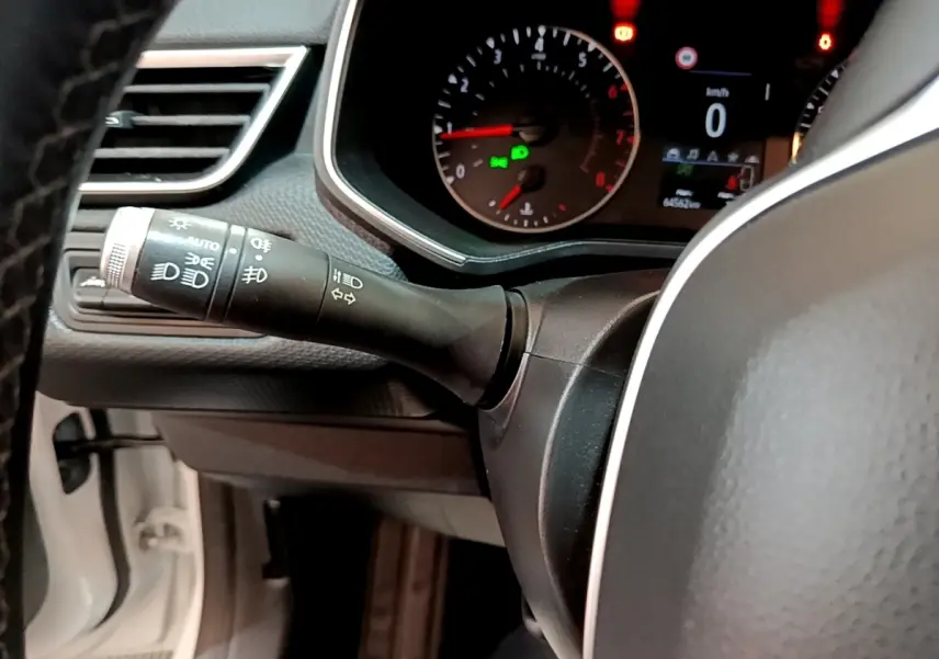 Gros plan sur le tableau de bord et la manette des phares d'une Renault Clio Business blanche de 2019.