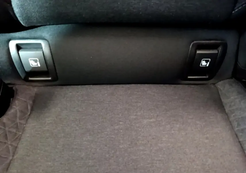 Gros plan sur les commandes de rabattement des sièges arrière du Renault Clio Business TCe 100, tissu gris.