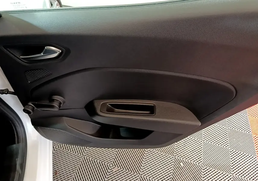 Gros plan sur la porte côté gauche d'une Renault Clio Business blanche, avec poignée manuelle et panneau noir.