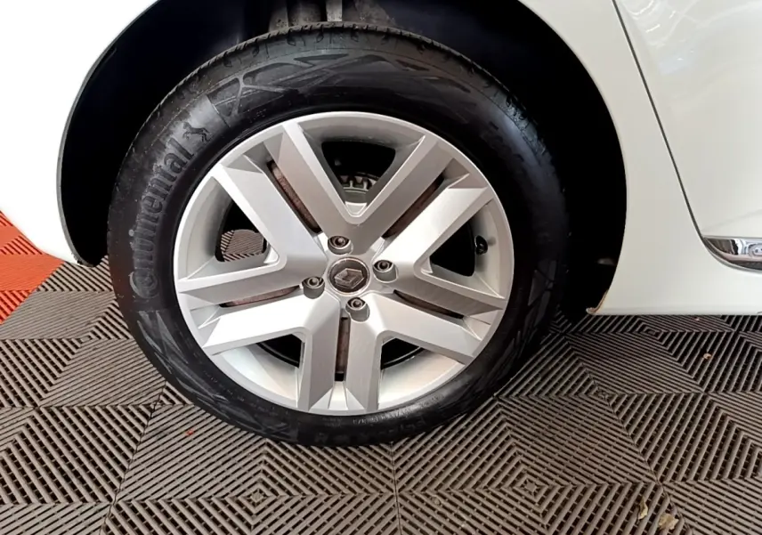 Gros plan sur la roue avant droite d'une Renault Clio Business TCe 100 blanche avec jante alliage moderne.