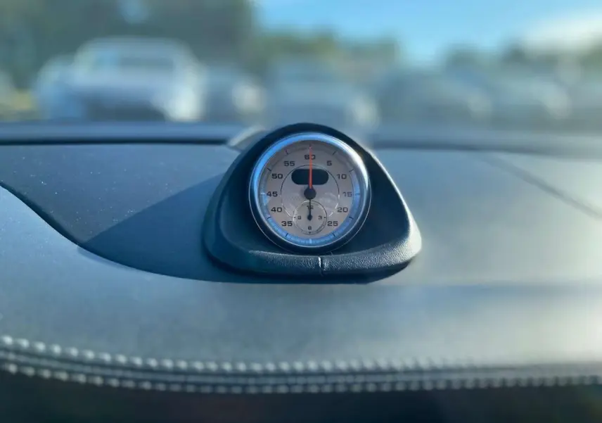 Gros plan sur le chronomètre analogique et numérique du tableau de bord en cuir noir d'une Porsche 911 997 Carrera 4S 2007.