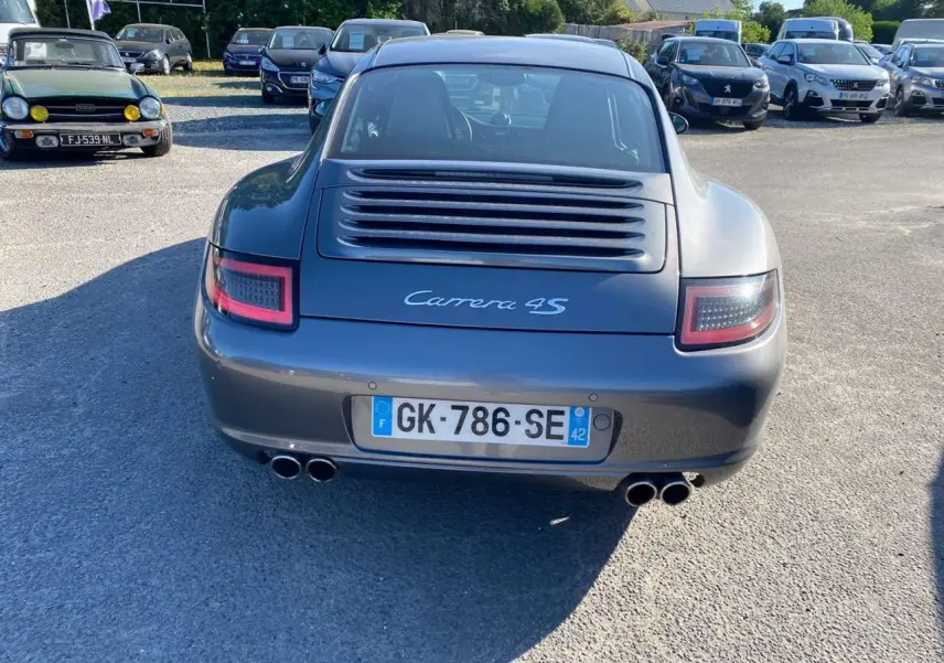 Vue arrière d'une Porsche 911 Carrera 4S 2007 gris météore avec double sortie d'échappement et feux arrière LED.
