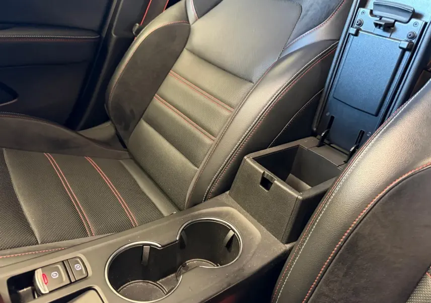 Gros plan sur siège avant noir cuir-suédine avec surpiqûres rouges et accoudoir central ouvert Renault Arkana.