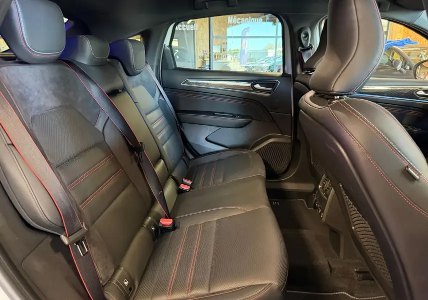 Vue latérale intérieure montrant la banquette arrière noire avec surpiqûres rouges du Renault Arkana 1.6 E-Tech hybrid RS LINE.