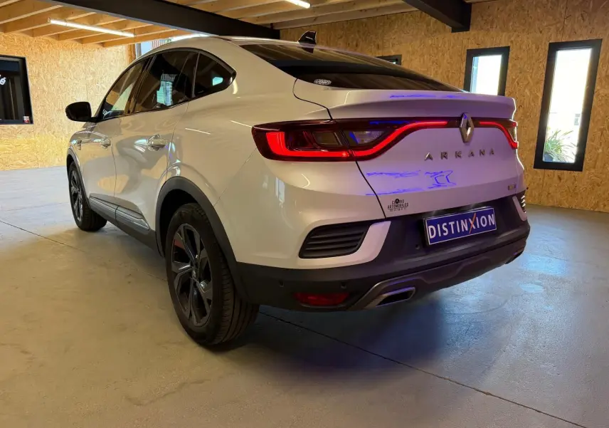 Vue 3/4 arrière droite d'un Renault Arkana blanc nacré avec feux LED et double sortie d'échappement chromée.