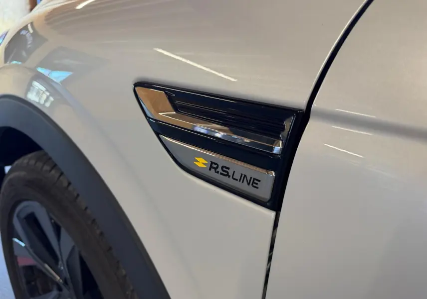 Détail de l'aile avant gauche blanche nacrée du Renault Arkana 1.6 E-Tech hybrid 145 RS LINE avec logo RS LINE.