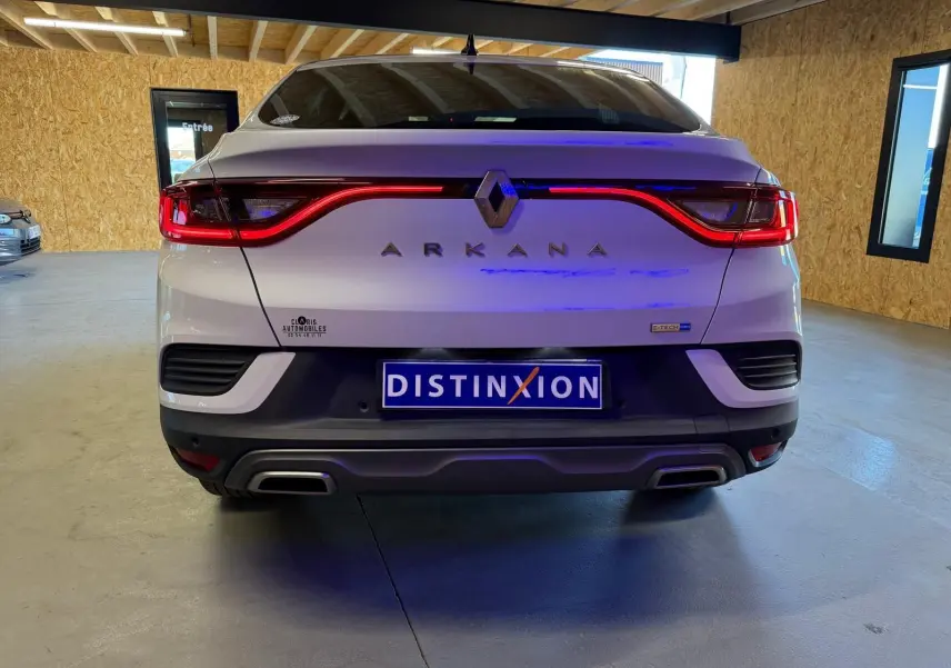 Vue arrière d'une Renault Arkana blanc nacré avec feux LED en forme de vague et double sortie d'échappement chromée.