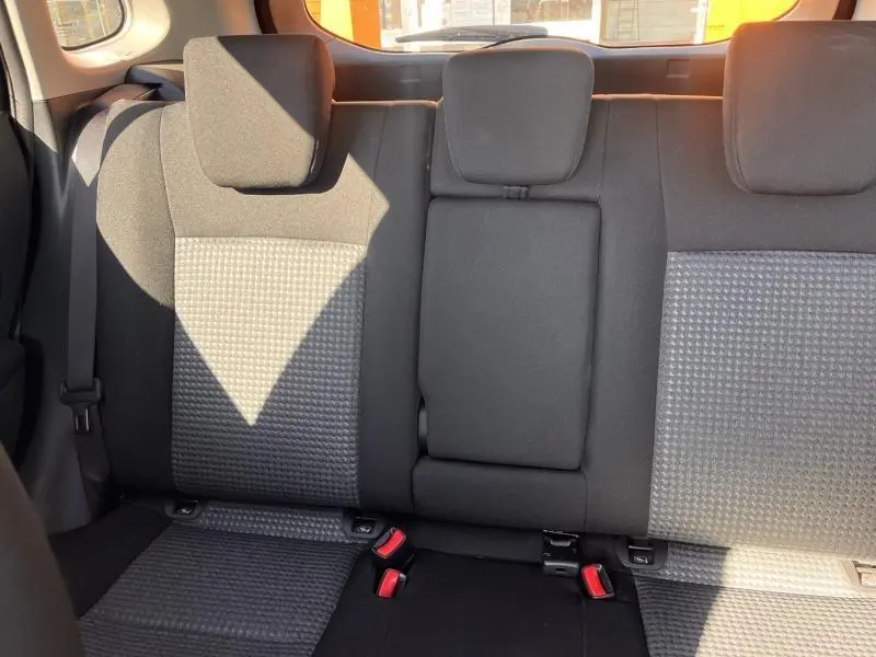 Vue intérieure de la banquette arrière noire du Suzuki S-Cross 2024 avec accoudoir central rabattable et appuie-têtes.