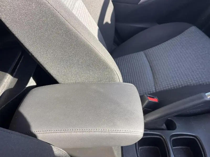 Accoudoir central en tissu noir et siège avant gris à motifs du Suzuki S-Cross 2024, vue rapprochée côté droit.