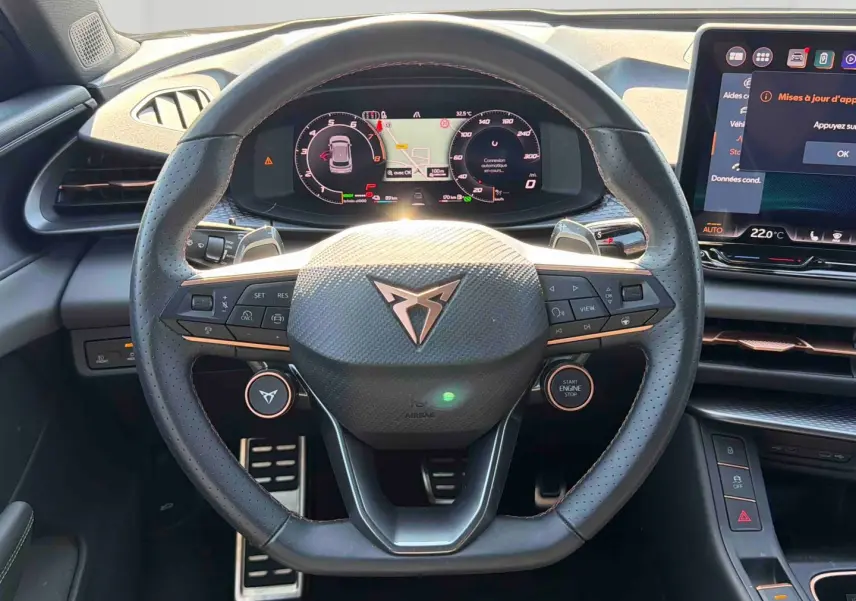 Vue intérieure centrée sur le volant sport cuir noir de la CUPRA TERRAMAR avec tableau de bord numérique et écran tactile.