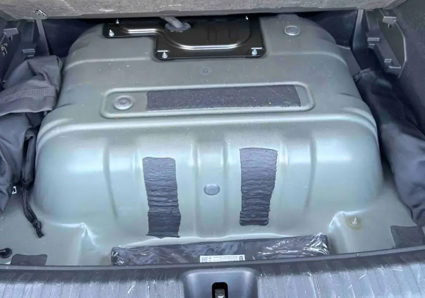 Vue du coffre ouvert d'une CUPRA TERRAMAR 2025 gris, montrant la partie inférieure du compartiment de rangement.