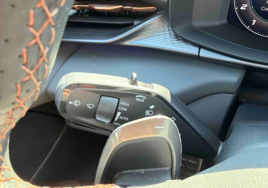 Gros plan sur la manette de commande des essuie-glaces à gauche du volant cuir perforé du CUPRA TERRAMAR gris 2025.
