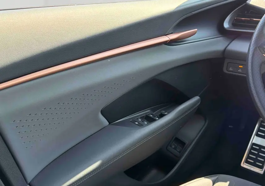 Vue intérieure côté conducteur du CUPRA TERRAMAR 2025, montrant la porte avec commandes électriques et garniture grise élégante.