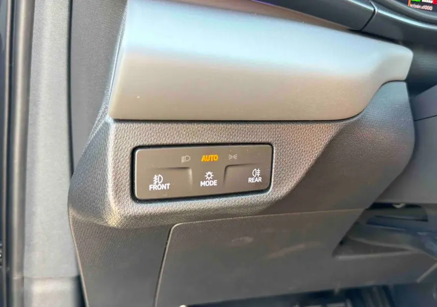 Gros plan sur les commandes d’éclairage au tableau de bord d’une CUPRA TERRAMAR 1.5 eHybrid grise, intérieur noir.