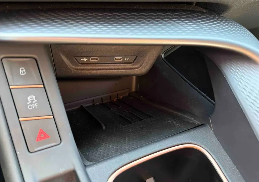 Gros plan sur la console centrale intérieure du CUPRA TERRAMAR 1.5 eHybrid gris, avec ports USB et boutons de contrôle.