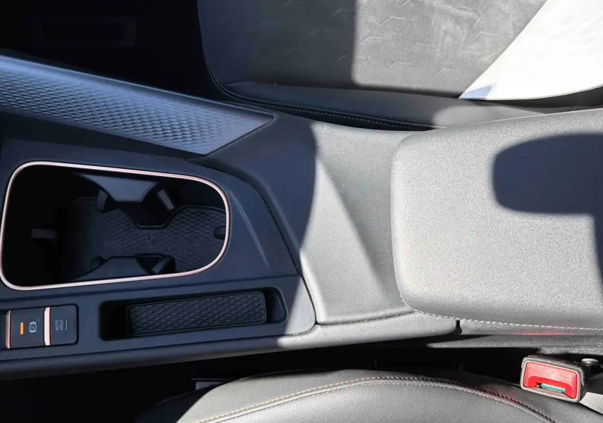 Vue plongeante sur la console centrale grise du CUPRA TERRAMAR 1.5 eHybrid avec porte-gobelets et frein électrique.