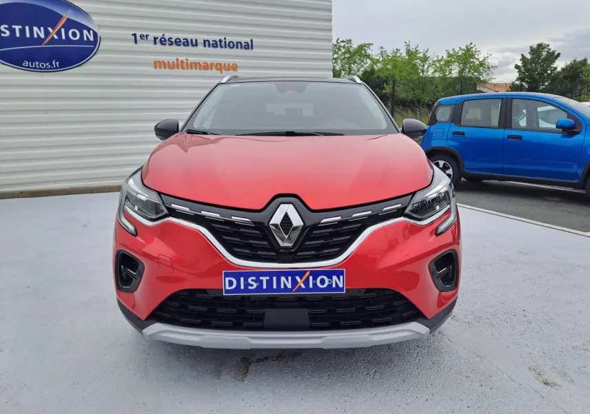 Vue de face du Renault Captur TCE 90CH TECHNO 2024 en rouge flamme métal, avec calandre noire et logo Renault bien visible.