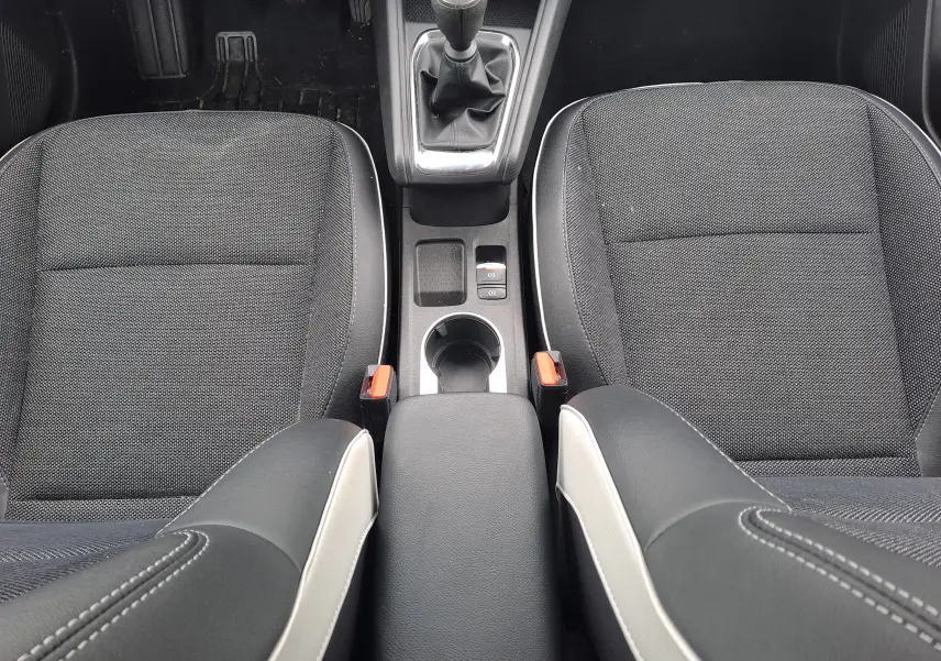 Vue plongeante sur les sièges avant noirs et la console centrale avec levier de vitesse manuelle du Renault Captur 2024.