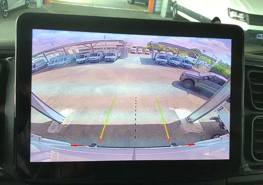 Vue arrière depuis la caméra de recul du Peugeot Boxer Fourgon blanc, montrant un parking avec plusieurs véhicules blancs stationnés.