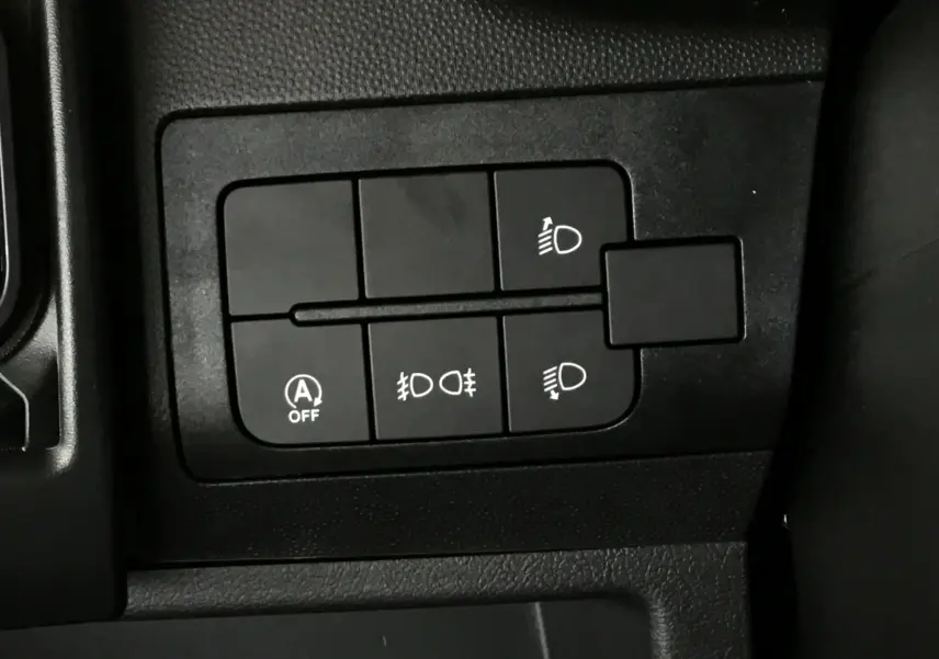 Panneau de commandes noires avec boutons d'éclairage et arrêt auto start dans l'habitacle du Peugeot Boxer Fourgon blanc.