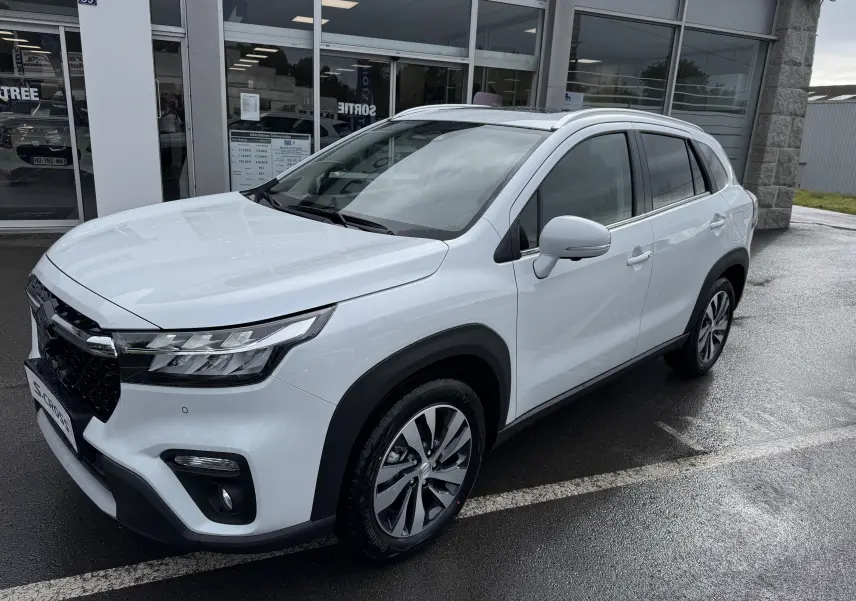Suzuki S-Cross blanc en 3/4 avant droit, mettant en valeur ses lignes modernes et ses jantes alliage distinctives.