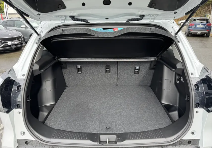 Coffre ouvert vu de l'arrière d'un Suzuki S-Cross blanc 2025, montrant un espace de chargement propre et spacieux.