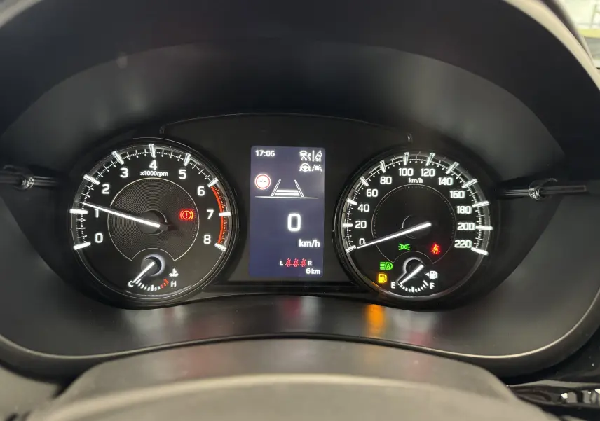 Vue rapprochée du tableau de bord du Suzuki S-Cross 1.4 hybride 2025, affichant compte-tours, vitesse et voyants allumés.