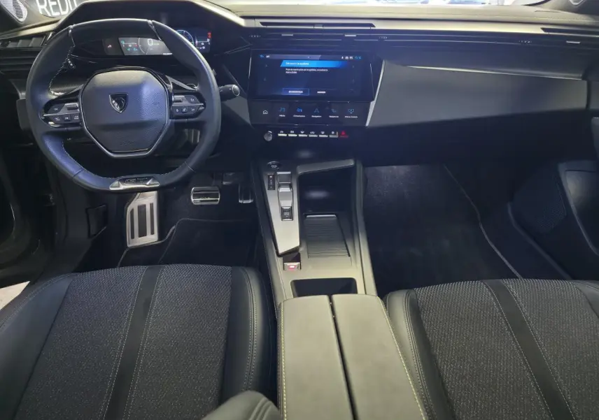 Vue intérieure avant de la Peugeot 408 GT 2025, tableau de bord moderne avec écran tactile 10 pouces et volant compact GT.
