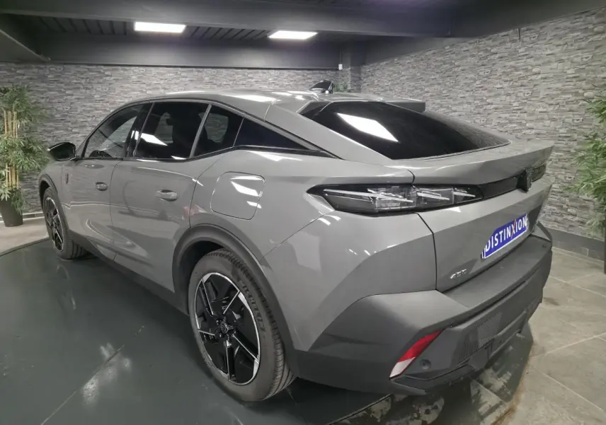 Vue 3/4 arrière droite de la Peugeot 408 gris métallisé avec jantes alliage 19 pouces et feux arrière LED griffés.