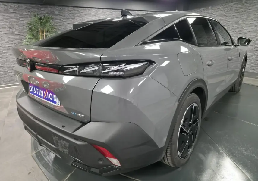 Vue 3/4 arrière droite de la Peugeot 408 gris métallisé avec jantes alliage noires et feux arrière à LED griffés.